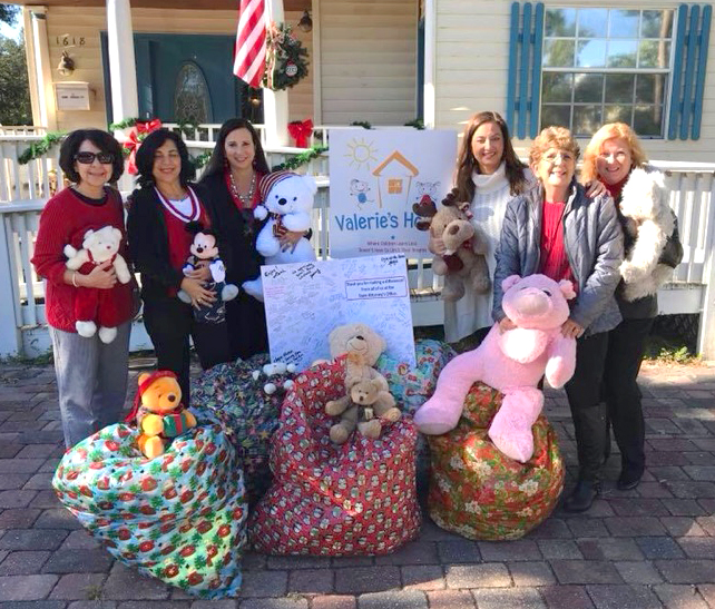 State Attorney Amira Fox with several Victim Advocates and their collected toy donations for Valerie's house.